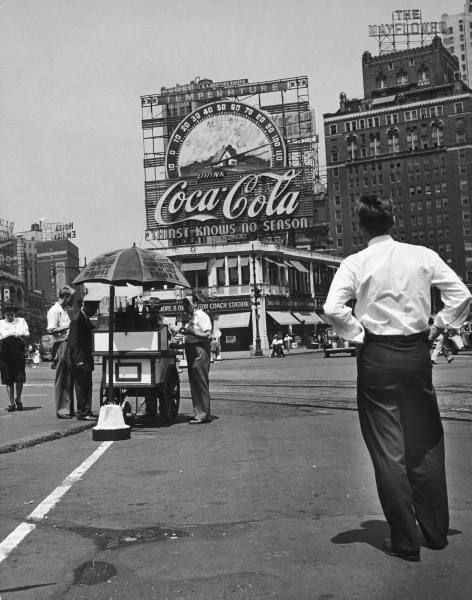 "Columbus Circle during heat wave. Large Coca Cola sign and thermometer registering 100 degrees on top of building next to the Mayflower Hotel." August 1944.